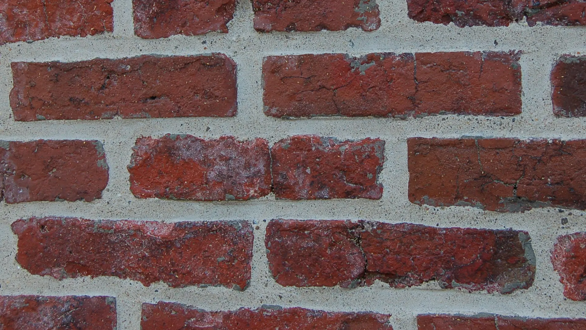 Red brick wall with freshly repointed mortar joints, tuckpointing