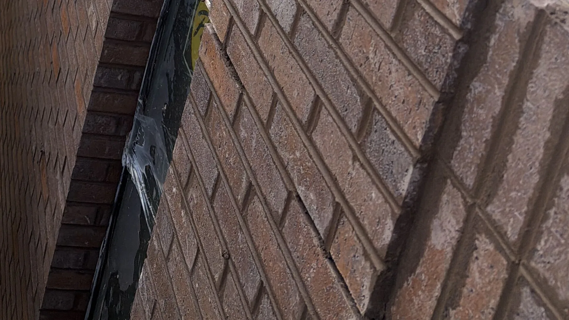 New brick veneer courses with tooled mortar joints, brick masonry