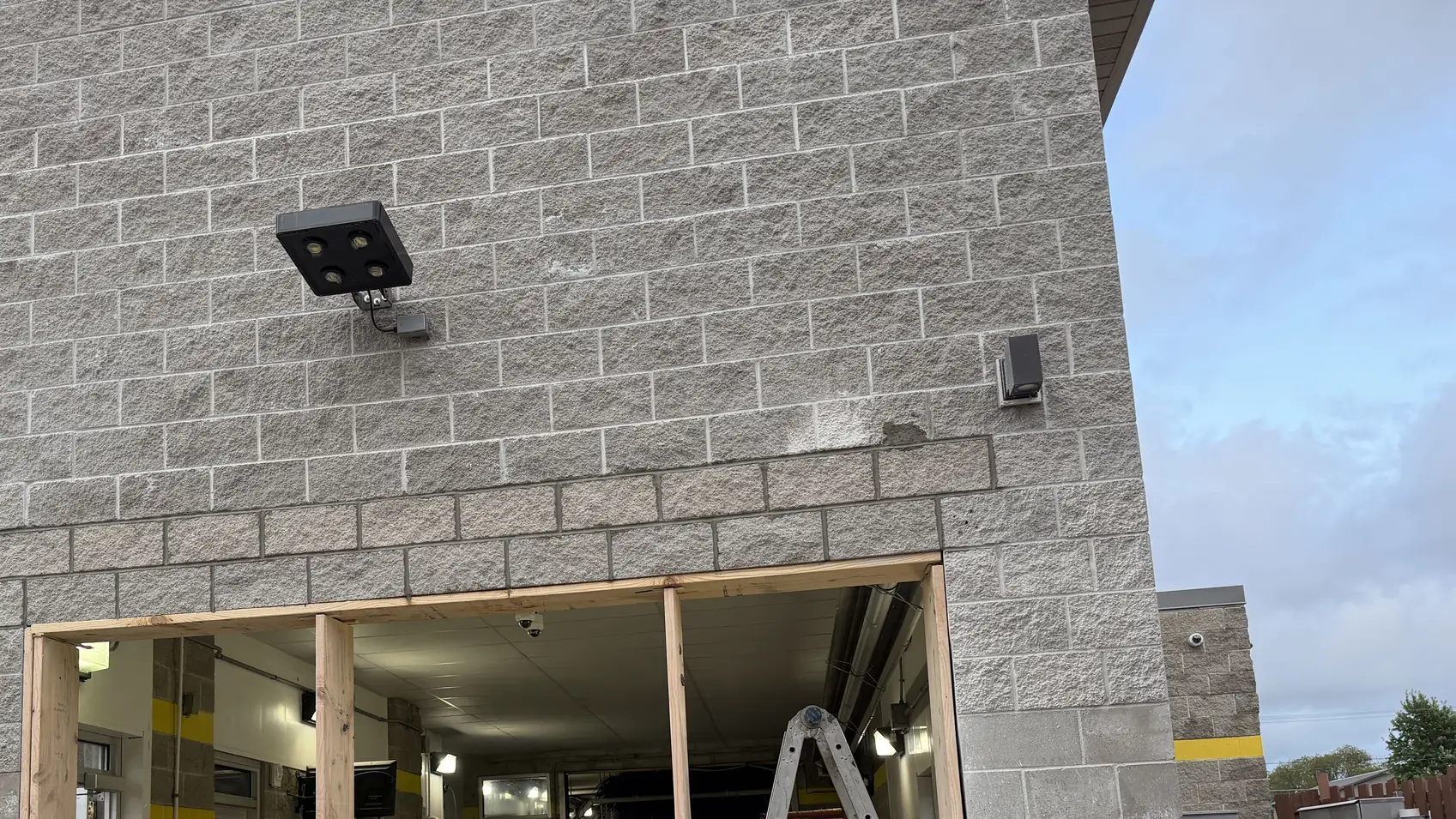 Split-face concrete block walls on a commercial building with a framed new opening, commercial masonry