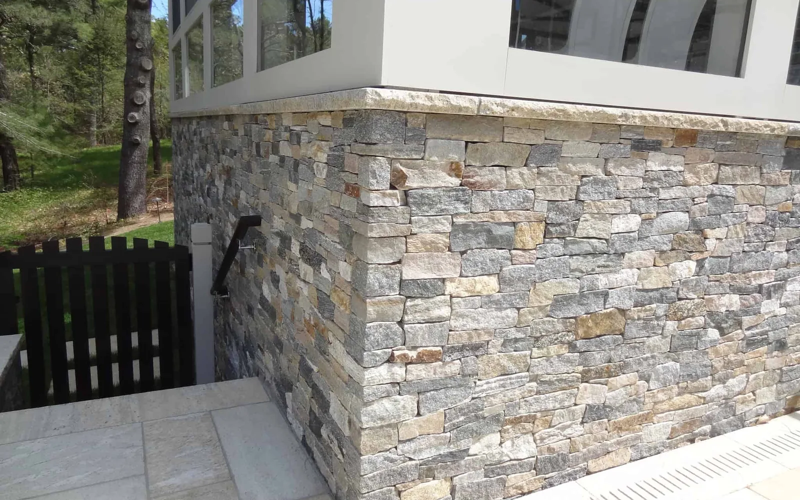 Stacked ledgestone veneer on the lower walls and corner of a house, stone masonry